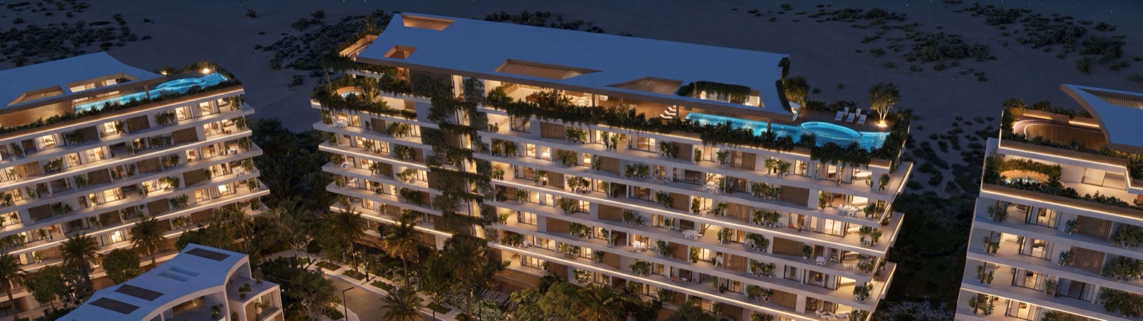 Aerial night view of Lunaya Terraces rooftop pools glowing above the residences